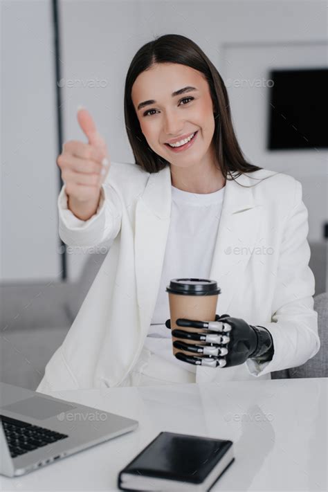 Girl With Disability In White Suite With Bionic Hand Prosthesis Holds