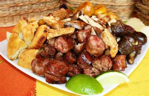 A Plate Full Of Meat And Chips On A Table Next To Baskets With Limes