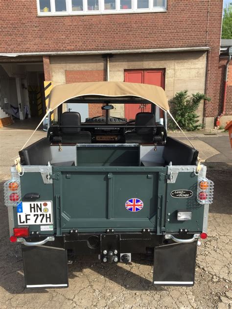 The Back End Of A Green Truck Parked In Front Of A Brick Building With