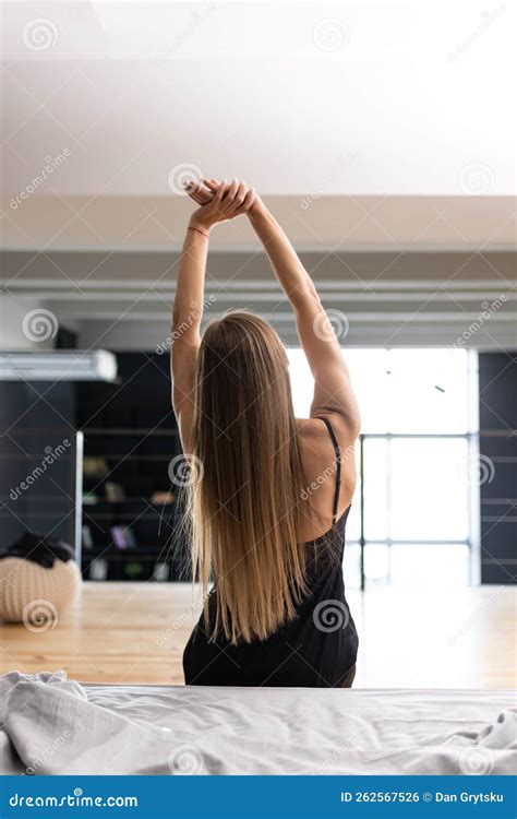 Rear View Of Woman Stretching In Bed After Wake Up In Morning Stock