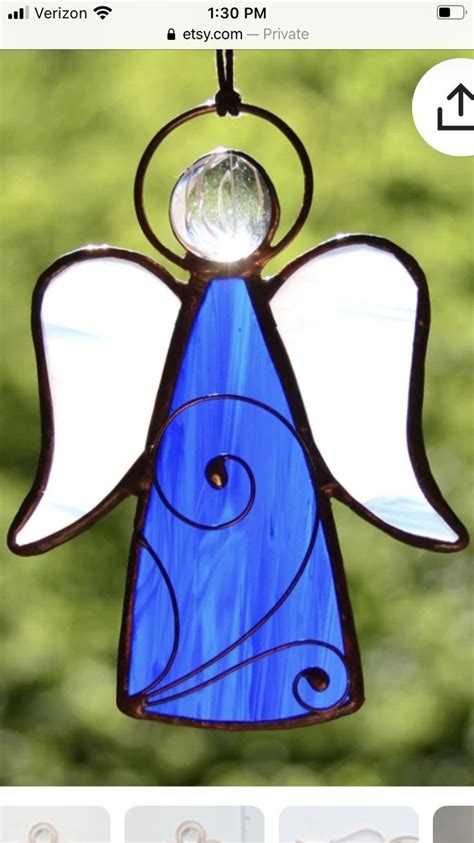 A Stained Glass Angel Ornament Hanging From A Window