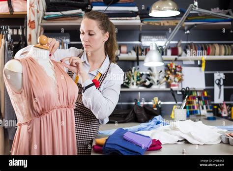 Woman Professional Sewer Measuring Dress At Mannequin Workshop Stock