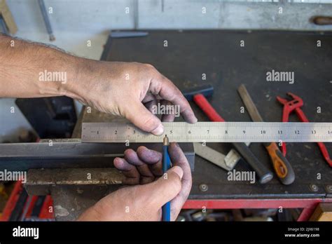 Image des mains sales d un forgeron qui avec une règle et un crayon