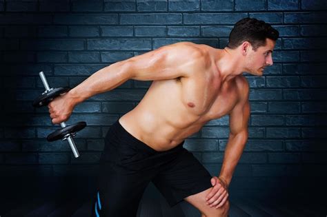 Premium Photo Bodybuilder Lifting Dumbbell Against Black Background