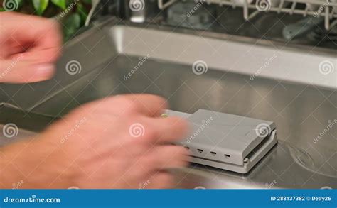 Loading The Tablet Into The Dishwasher A Man Puts Tablet In The