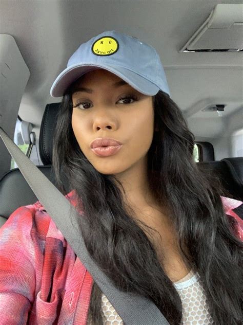 A Woman Sitting In The Back Seat Of A Car Wearing A Hat With A Smiley