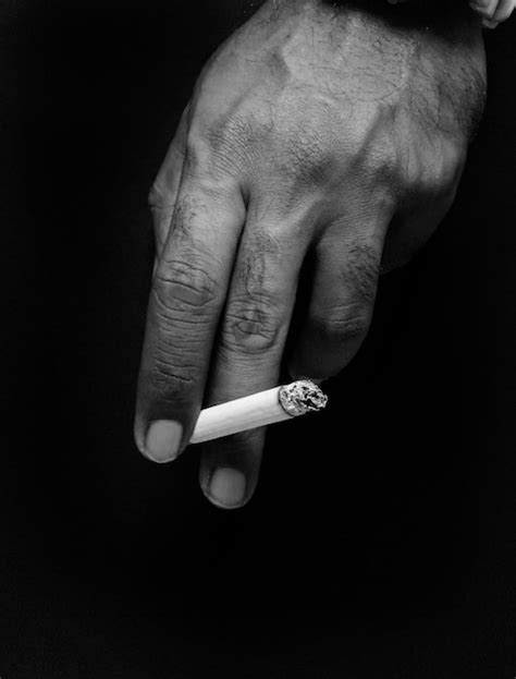 Premium Photo Cropped Hand Holding Cigarette Against Black Background