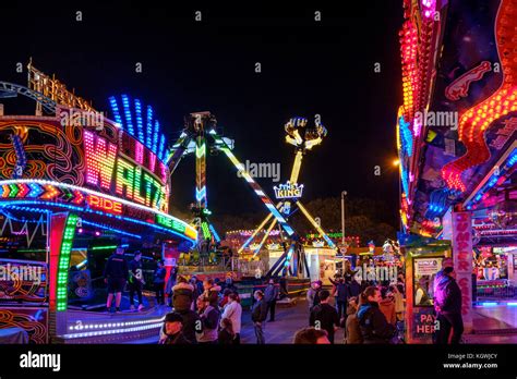 People and fairground rides at night, Goose Fair, Nottingham, England ...