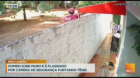 Homem sobre muro e é flagrado por câmera de segurança furtando tênis