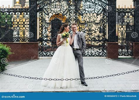 Recienes Casados Que Se Colocan Delante De Las Puertas Foto De Archivo