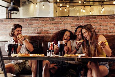 Group Of Friends Having Pizza At Cafe Cheerful Young People Eating