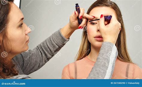 Make Up Artist In Photo Studio Doing Makeup For Beautiful Girl Woman