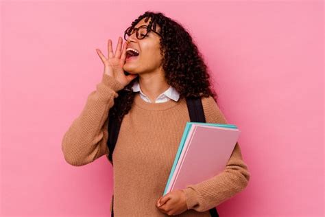 Mujer De Raza Mixta Joven Estudiante Aislada Sobre Fondo Rosa Gritando