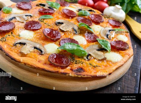 Tasty Italian Pizza With Salami Mushrooms Mozzarella Basil On A Dark