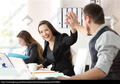 Zwei glückliche Mitarbeiter feiern Erfolg im Büro Lizenzfreies Bild