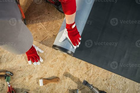 Roofing Worker Installing EPDM Rubber Membrane on Top of Plywood Roof ...