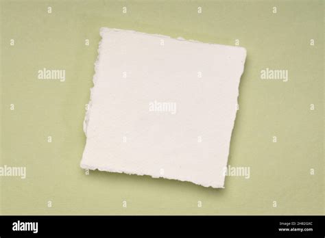 Small Square Sheet Of Blank White Khadi Paper Against Green Rag Paper