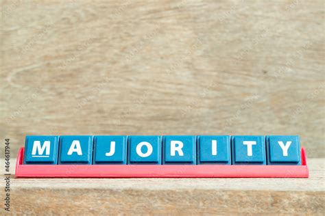 Tile Alphabet Letter With Word Majority In Red Color Rack On Wood