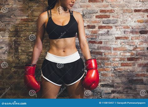 Female Muscular Sport Boxer With Boxing Gloves Posing Over Wall Stock