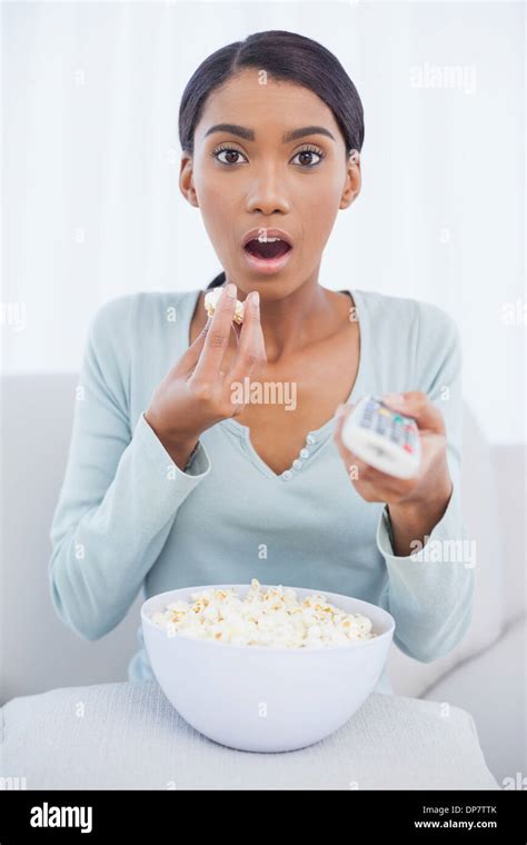 Astonished Attractive Woman Eating Popcorn While Watching Tv Stock