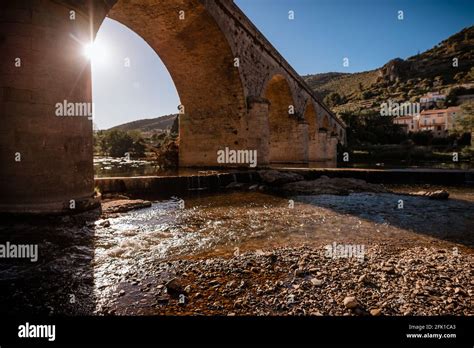 Old Stone Arch Bridge Across River In Mediterranean French Village