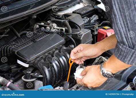 Man Or Auto Mechanic Worker Hands Checking The Car Engine Oil And