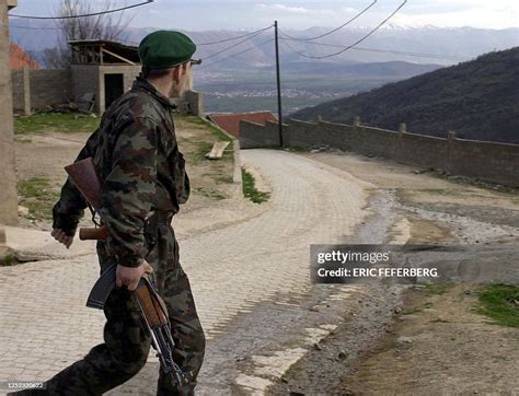 An UCK combatant walks through the village of Selce which overlooks ...
