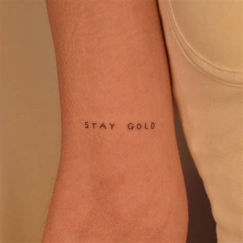 Tattoo That Says Stay Gold Handwritten On The Bicep