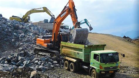 Doosan DX300 LCA Excavator With Dump Trucks Working On The Dam