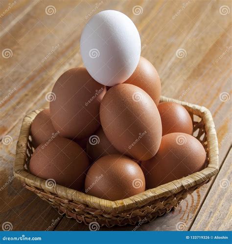 Group Of Chicken Brown Eggs And One White Lie In A Wicker Basket Stock