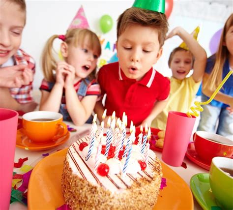 Niños Soplando Las Velas En La Fiesta De Cumpleaños Foto Gratis