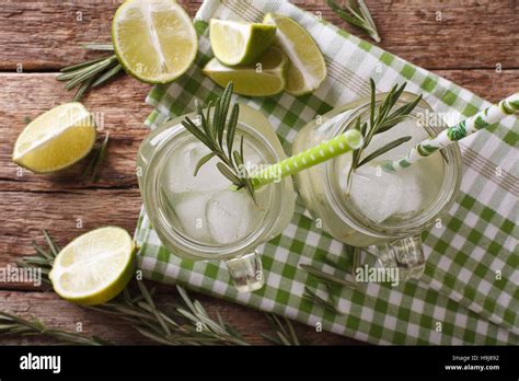 Cold Cocktail With Lime Ice And Rosemary Close Up In A Glass Jar