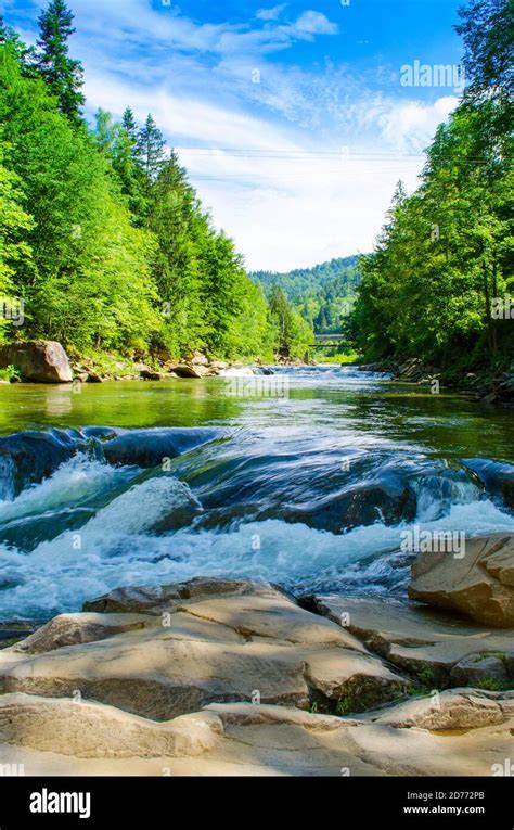 mountain river with a rapid current of rocks with a waterfall in summer ...