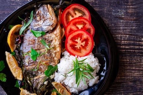 Pescado dorada a la plancha con limón perejil romero y tomates con