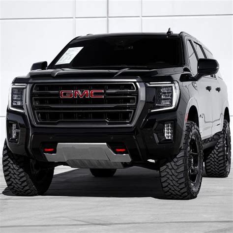 The Front End Of A Black And White Gmc Truck Parked In A Parking Lot