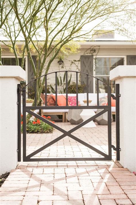 An Open Gate Leading To A House With A Couch In The Background