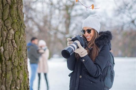 Premium Photo Woman Photographing On Tree Trunk During Winter