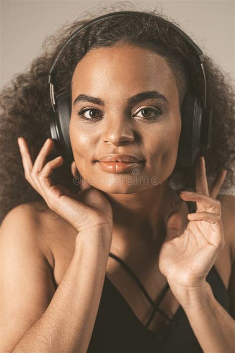 Young African American Girl Listening Music In Headphones Wearing Black