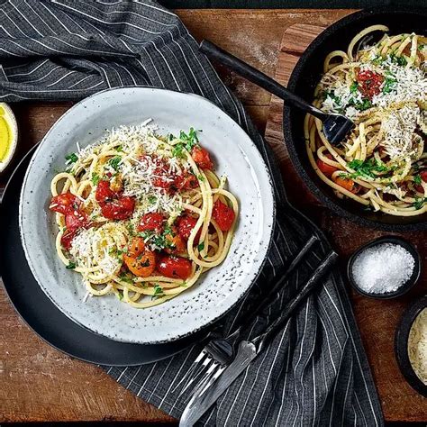 A Plate Of Spaghetti With Tomatoes And Parmesan Cheese