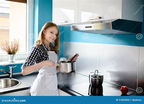 Beautiful Blonde Woman Cooking In The Modern Kitchen Stock Image