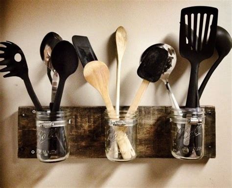 Spoons And Spatulas Are Lined Up In Mason Jars On A Wooden Rack