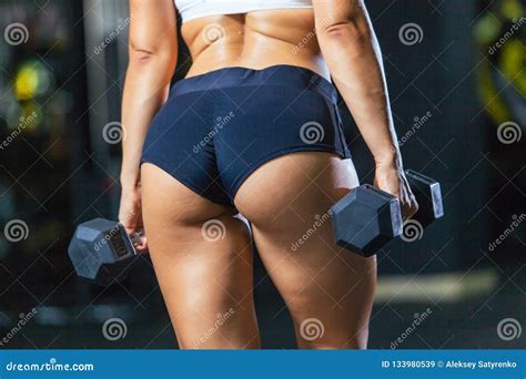 Athletic Buttocks Of Fit Girl Wearing Sporty Shorts With Dumbbells In