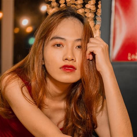 Una Mujer Con Un Vestido Rojo Posa Frente A Un Cartel De Coca Cola