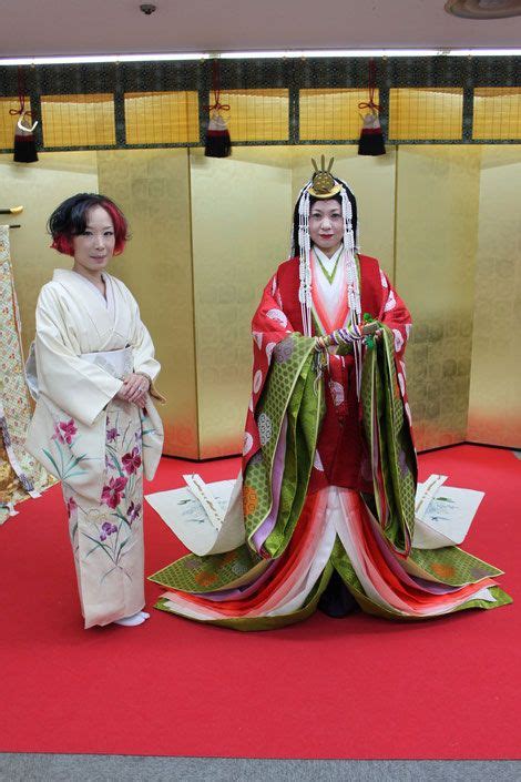 A Woman Dressed In Junihitoe Along With Another In Modern Kimono