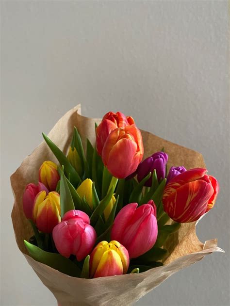 a bouquet of colorful tulips sitting on top of a table