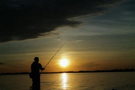 Silhueta De Um Homem Pescando No Mar Contra O C U Durante O P R Do Sol