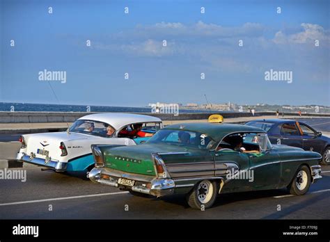 Old American Classic Cars Driving Down The Malecon Towards Downtown