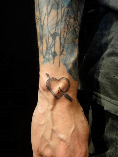 Heart And Arrow Tattoo On The Right Wrist