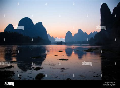 Limestone Karst Formations Reflected In River Li At Sunset Guilin