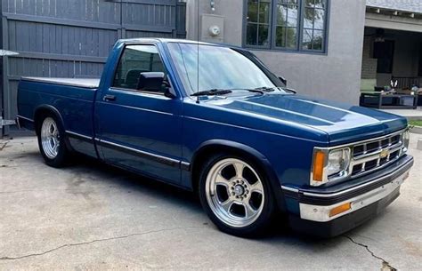 a blue pick up truck parked in front of a house